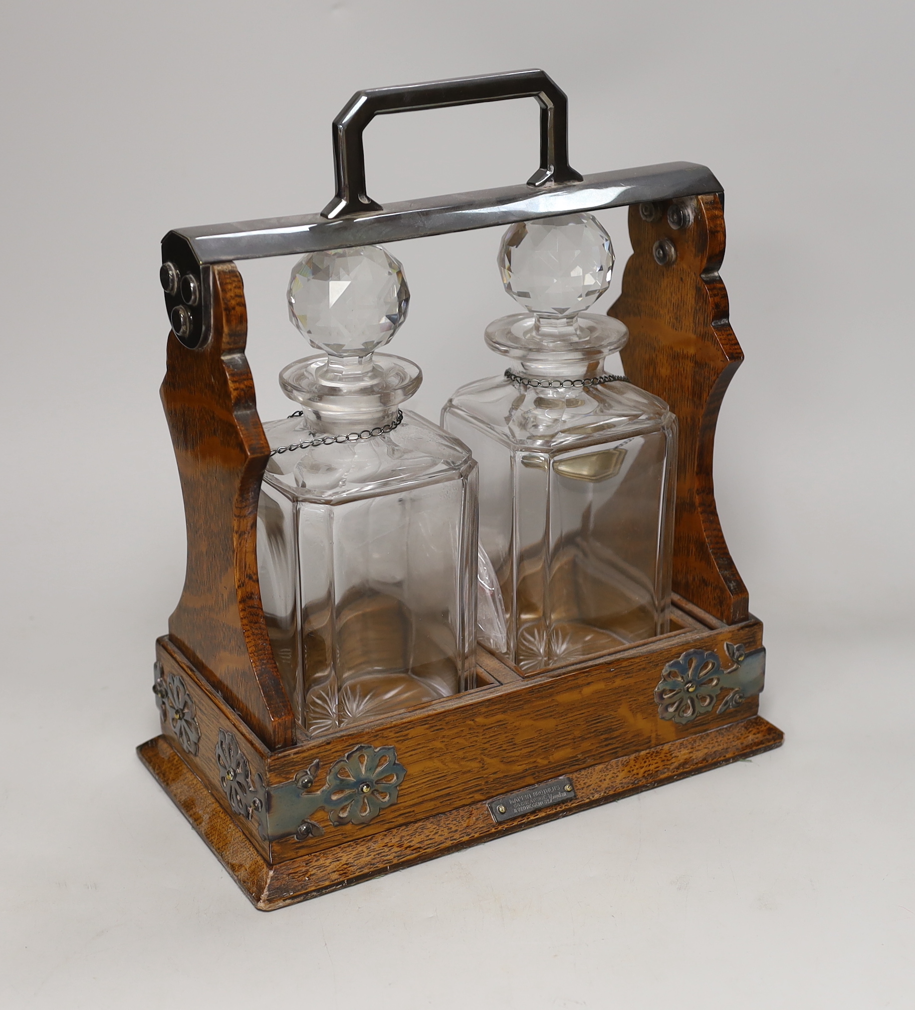 A Mappin Bros. oak and electroplate mounted two bottle tantalus, 31cm high